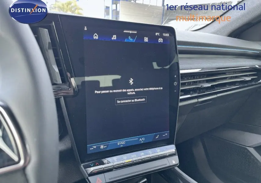 Vue rapprochée de l'écran tactile central du tableau de bord du Renault Austral blanc nacré 2025, affichant la connexion Bluetooth.