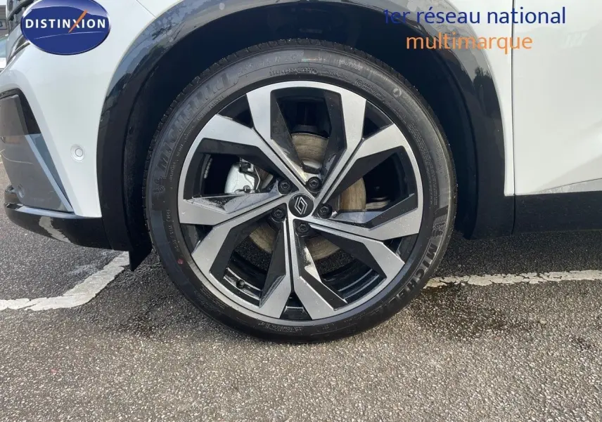 Gros plan sur la roue avant gauche du Renault Austral blanc nacré, mettant en valeur la jante alliage au design moderne.