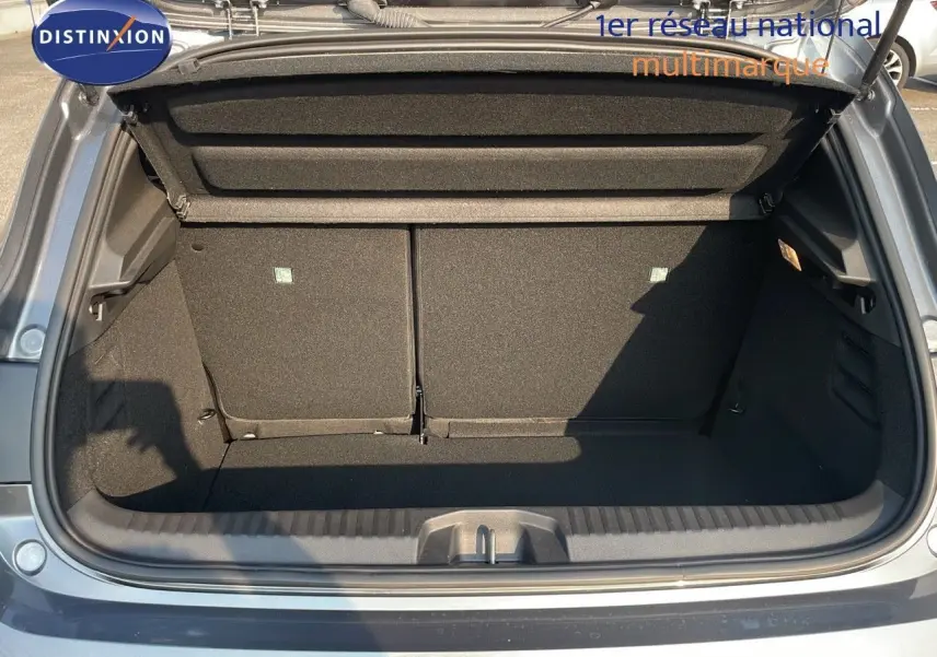 Coffre ouvert vu de l'arrière d'une Renault Clio gris schiste métal, montrant l'espace de chargement vide.