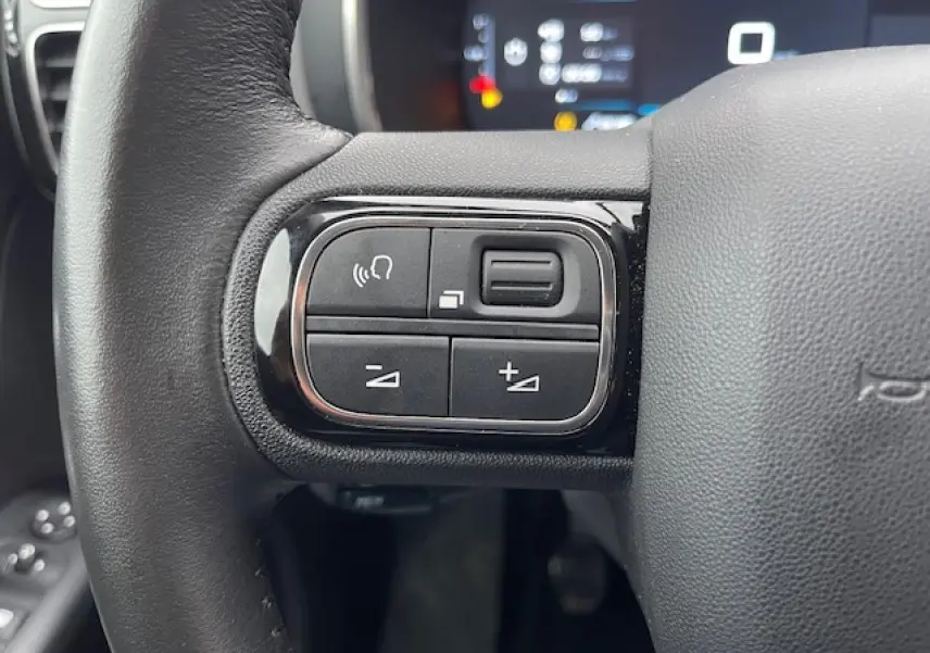Gros plan sur les commandes au volant gauche du Citroën C5 Aircross 2021, avec boutons de volume et téléphone.
