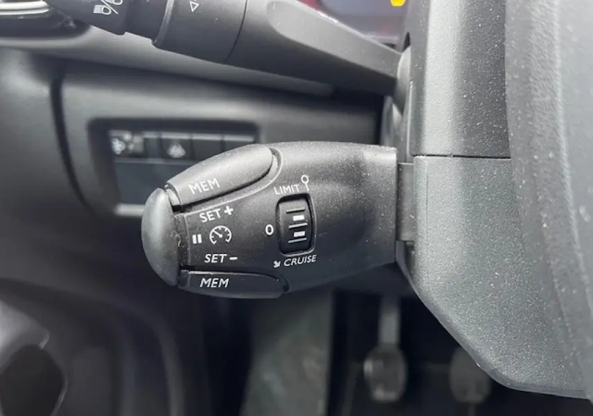 Gros plan sur la commande de régulateur de vitesse du Citroën C5 Aircross 2021, finition Feel Pack, intérieur noir.