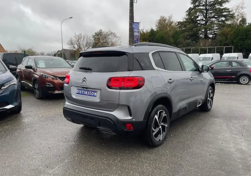 Vue 3/4 arrière droite d'un Citroën C5 Aircross gris Artense avec feux arrière LED et jantes alliage 18 pouces Swirl.
