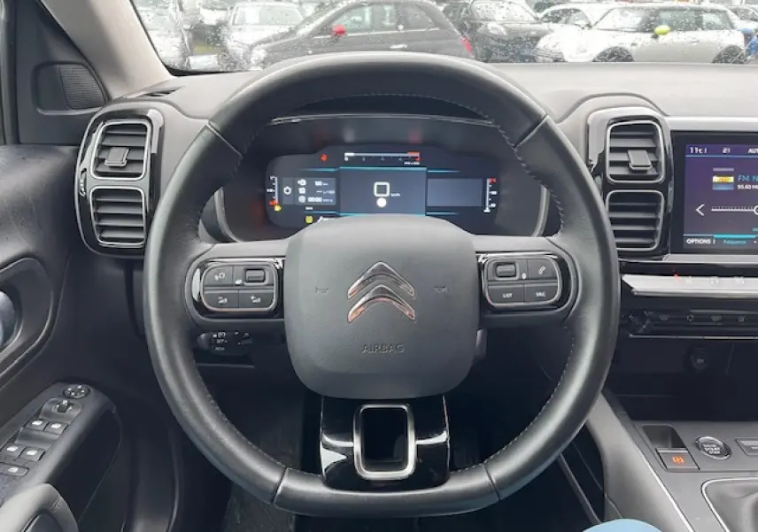 Vue centrée sur le volant et tableau de bord du Citroën C5 Aircross 2021, intérieur moderne noir avec écran tactile.