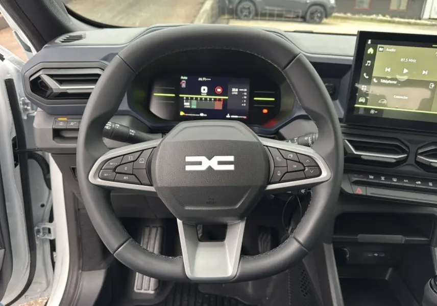 Vue centrée sur le volant et le tableau de bord numérique du Dacia Duster 2025, intérieur moderne et épuré.