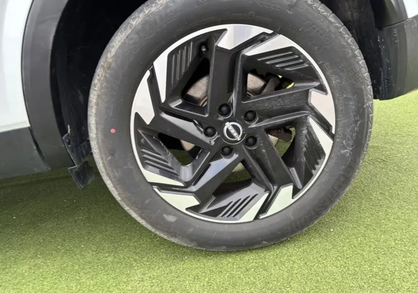 Gros plan sur la jante alliage noire et argent du Nissan Qashqai blanc nacré, côté droit, avec pneu Bridgestone.