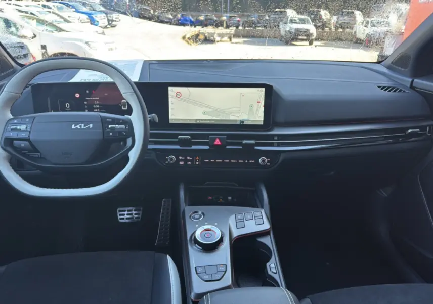 Vue intérieure avant du tableau de bord et volant noir du Kia Sportage 2026 avec écran GPS large et console centrale moderne.