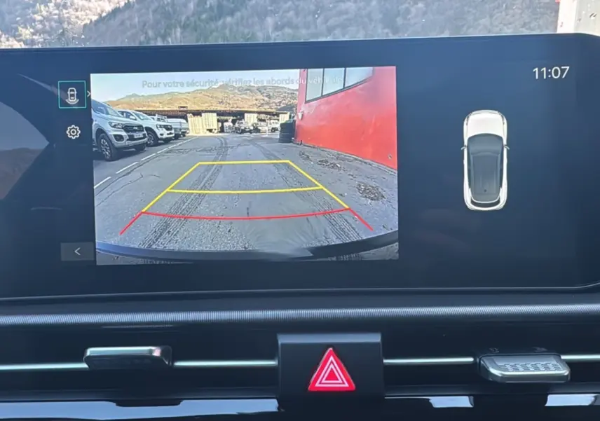 Écran multimédia affichant la caméra de recul du Kia Sportage noir étoilé avec lignes de guidage colorées.