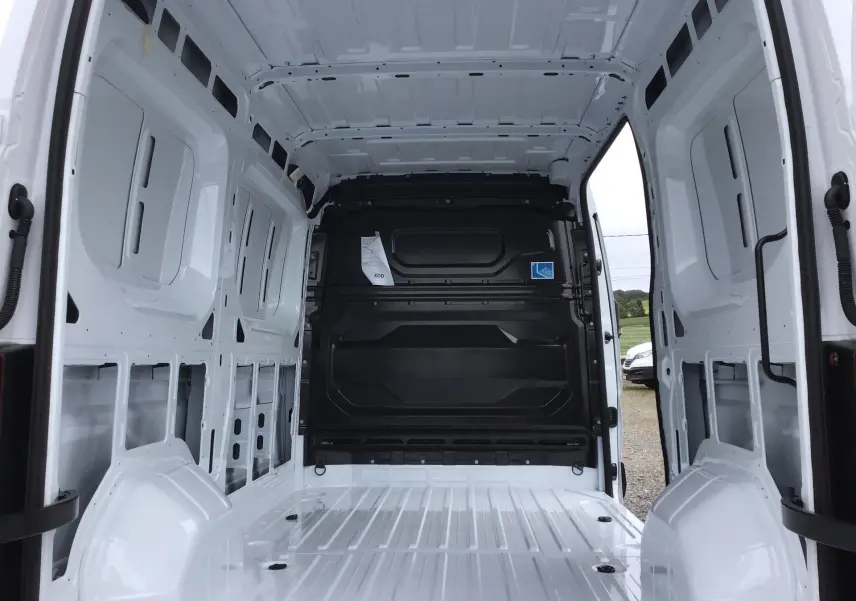 Vue intérieure arrière du Renault Master blanc L2H2 2025, montrant l'espace de chargement vide avec cloison noire.