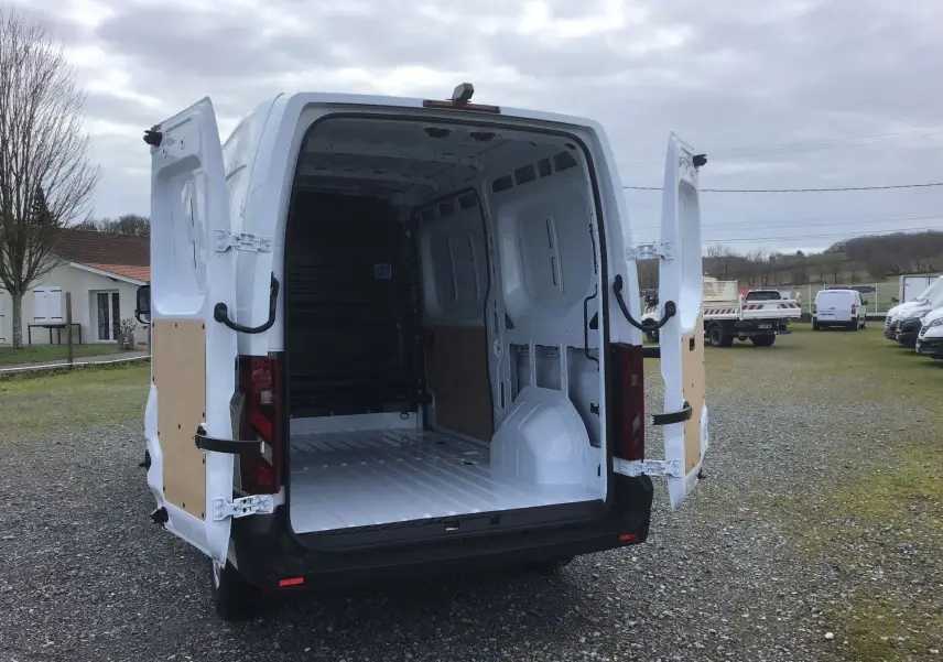 Vue arrière d’un Renault Master blanc 2025 avec portes arrière ouvertes montrant l’espace de chargement vide.