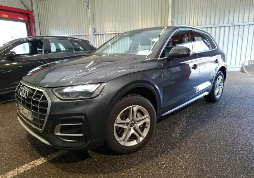 Vue frontale d'un Audi Q5 gris avec calandre imposante et phares LED allumés dans un garage.