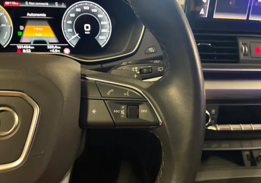 Gros plan sur le volant cuir noir d’un Audi Q5 2024 avec commandes multifonctions et tableau de bord numérique.