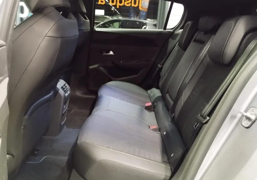 Vue côté droit de l’habitacle arrière de la Peugeot 308 gris Artense, montrant les sièges et les finitions intérieures.