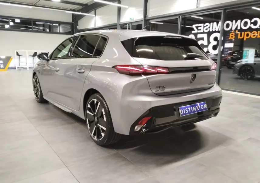 Peugeot 308 gris Artense vue 3/4 arrière droit en intérieur avec jantes alliage bi-tons et feux LED distinctifs.