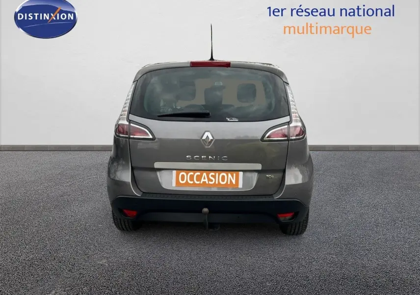 Vue arrière d’un Renault Scénic III gris 2015 avec attelage et plaque « occasion » visible.