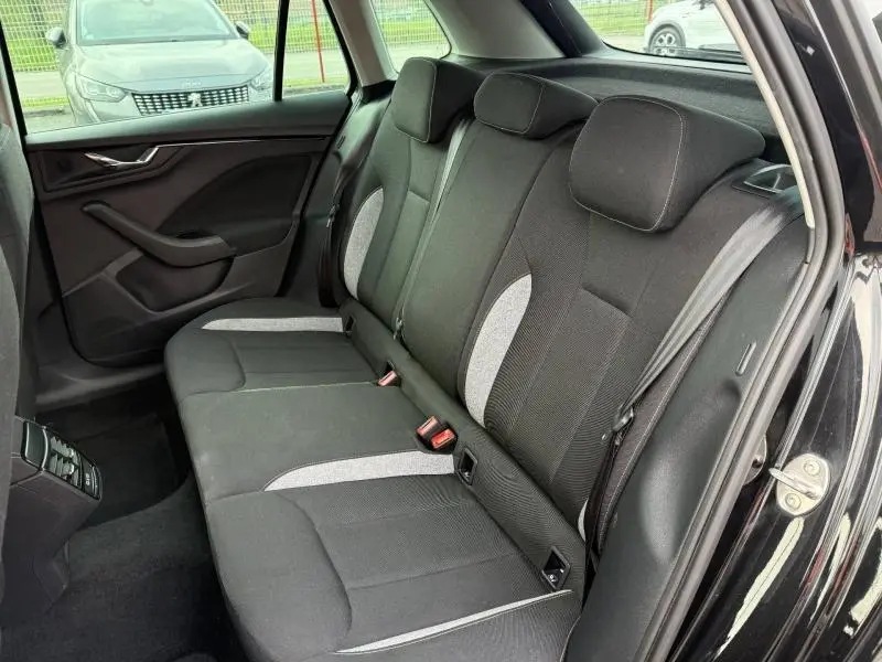 Vue intérieure arrière côté droit du Skoda Kamiq 2024 noir Magic nacré, montrant les sièges arrière en tissu bicolore.