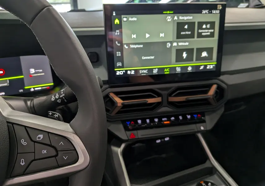 Intérieur du Dacia Bigster Hybrid-G 150 4x4 gris schiste, vue sur le volant et l’écran tactile central moderne.
