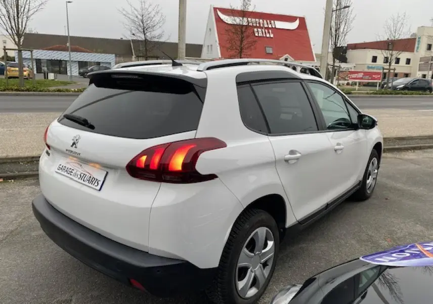 Vue 3/4 arrière droite d'un Peugeot 2008 blanc avec feux arrière à griffes 3D LEDs et vitres surteintées.