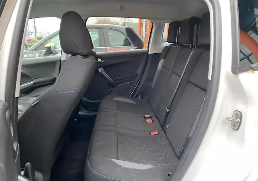 Vue intérieure côté gauche sur la banquette arrière noire du Peugeot 2008 blanc avec détails de couture bleue.