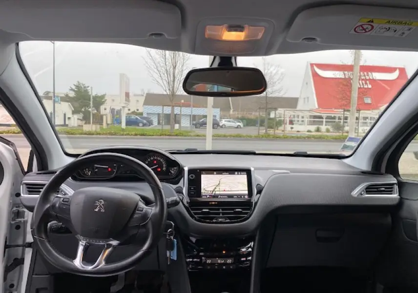 Intérieur Peugeot 2008 blanc vu de face, tableau de bord avec écran tactile 7 pouces et volant multifonctions.