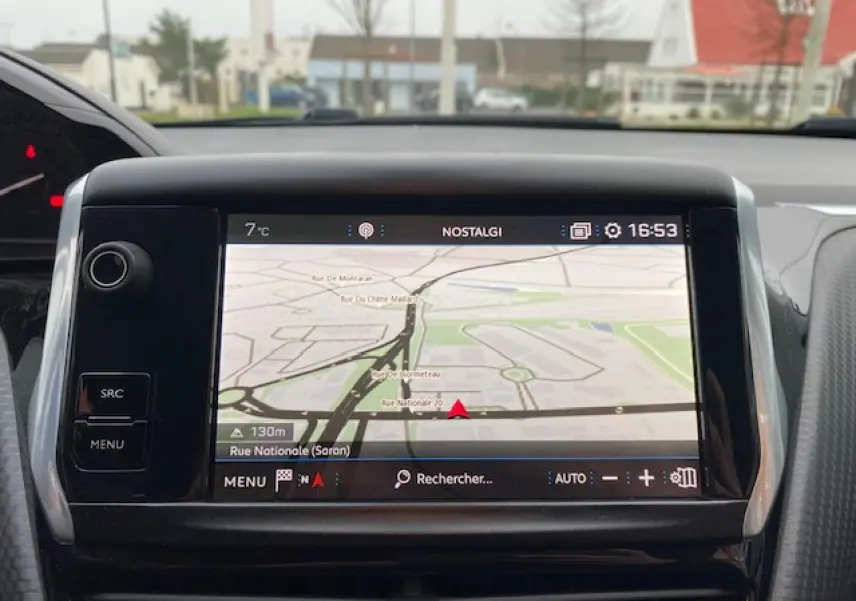 Écran tactile 7 pouces du système de navigation 3D connecté dans un Peugeot 2008 blanc, vue intérieure frontale.