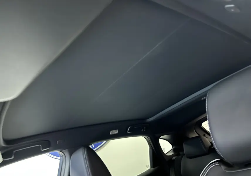 Toit panoramique fermé en noir sur l'intérieur du Nissan Qashqai gris céramique, vue depuis l'arrière côté droit.