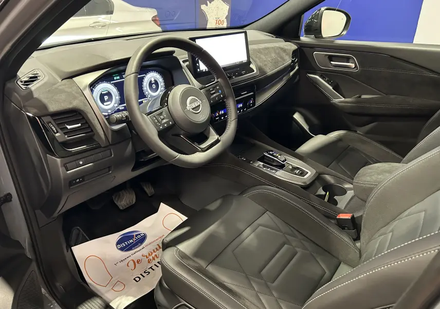 Vue intérieure côté conducteur du Nissan Qashqai 2025 avec sièges cuir noir et tableau de bord moderne.