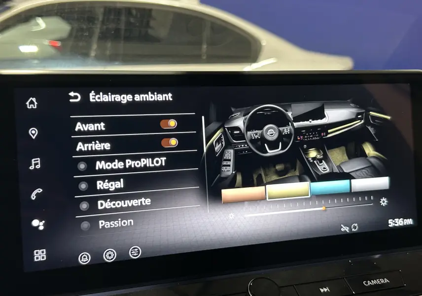 Vue intérieure du tableau de bord du Nissan Qashqai 2025 avec éclairage d'ambiance personnalisable et commandes tactiles.