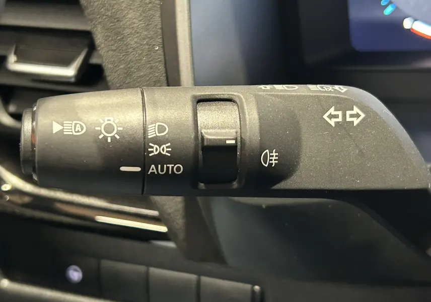 Le commodo d'éclairage et clignotants du Nissan Qashqai 2025, vue rapprochée côté gauche du volant.