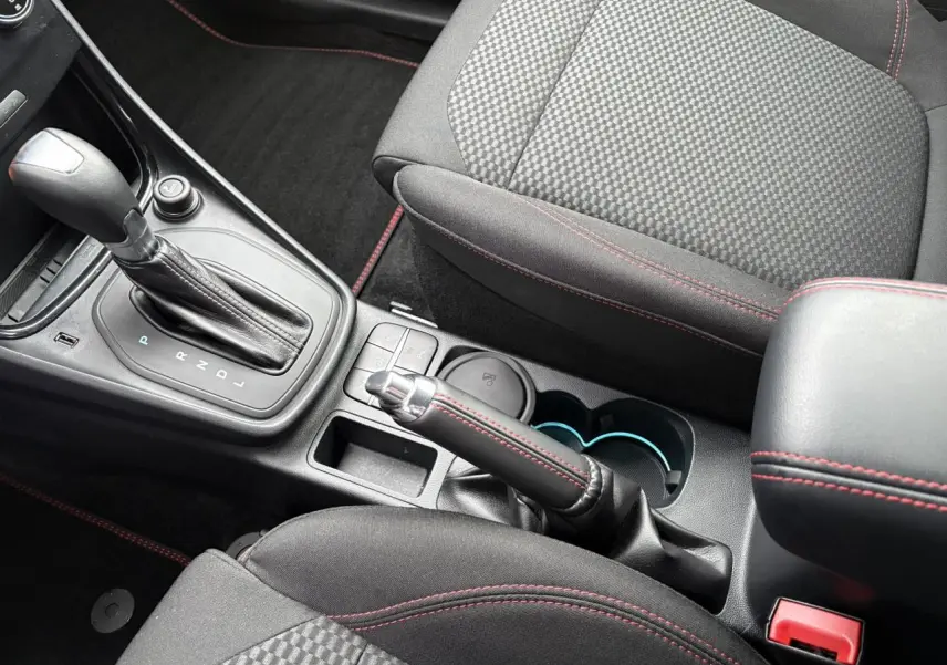 Vue rapprochée de la console centrale du Ford Puma ST Line 2023, avec levier de vitesse automatique et surpiqûres rouges.