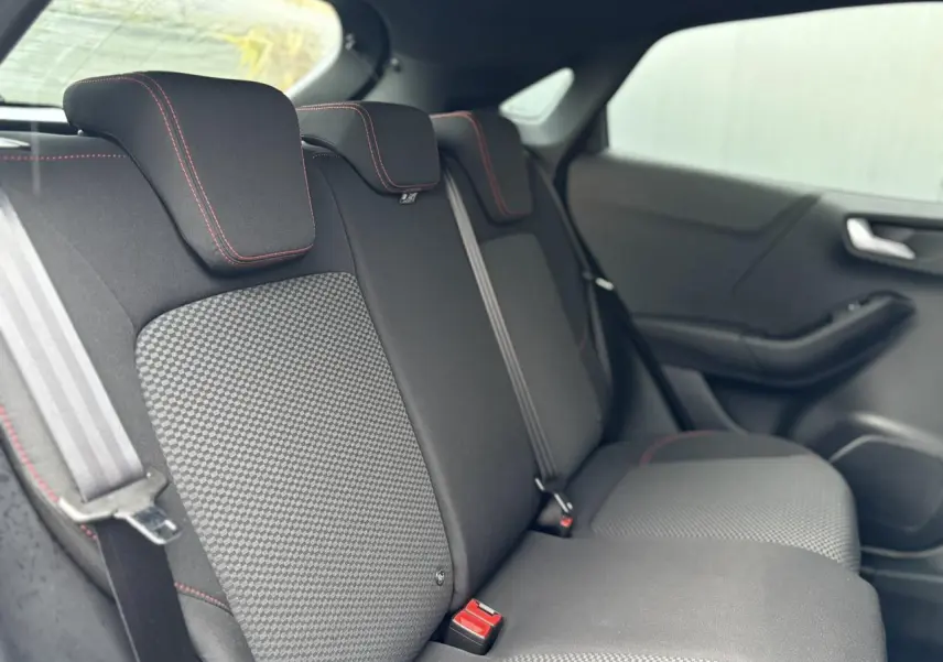 Vue intérieure du siège arrière droit du Ford Puma 2023 avec tissu gris et surpiqûres rouges contrastantes.