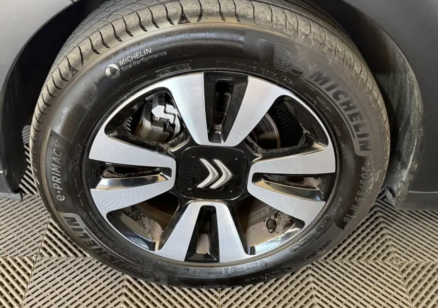 Gros plan sur la roue avant droite de la Citroën C3 blanche, jante alliage bicolore avec logo Citroën central.