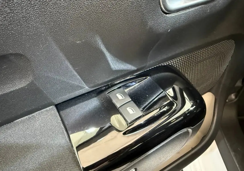 Gros plan sur les commandes de lève-vitres avant gauche d’une Citroën C3 blanche, finition Shine Business.