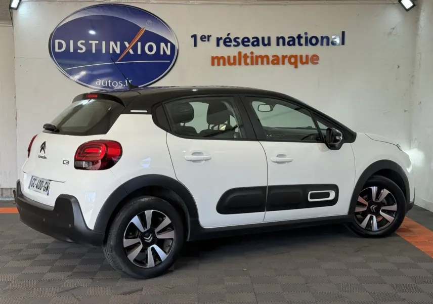 Vue de profil côté droit d'une Citroën C3 blanche avec toit noir et protections latérales noires distinctives.