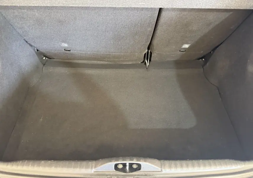 Vue intérieure du coffre spacieux de la Citroën C3 blanche, avec banquette arrière rabattue partiellement.