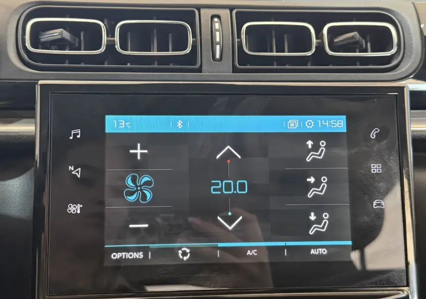 Écran tactile central de la Citroën C3 blanche, affichant la climatisation à 20°C, entouré de sorties d’air rectangulaires.