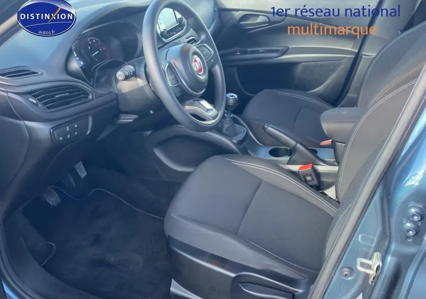 Vue intérieure côté conducteur de la Fiat Tipo 1.6 Multijet bleu, volant multifonction et boîte manuelle visibles.