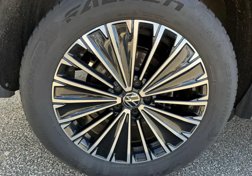 Gros plan sur la jante en alliage léger 18 pouces Napoli du Volkswagen Tiguan bleu, avec logo VW au centre.