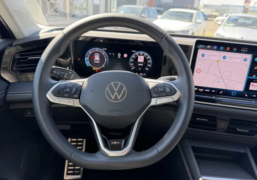 Vue intérieure centrée sur le volant cuir multifonction du Volkswagen Tiguan 2025 avec tableau de bord numérique et écran tactile.