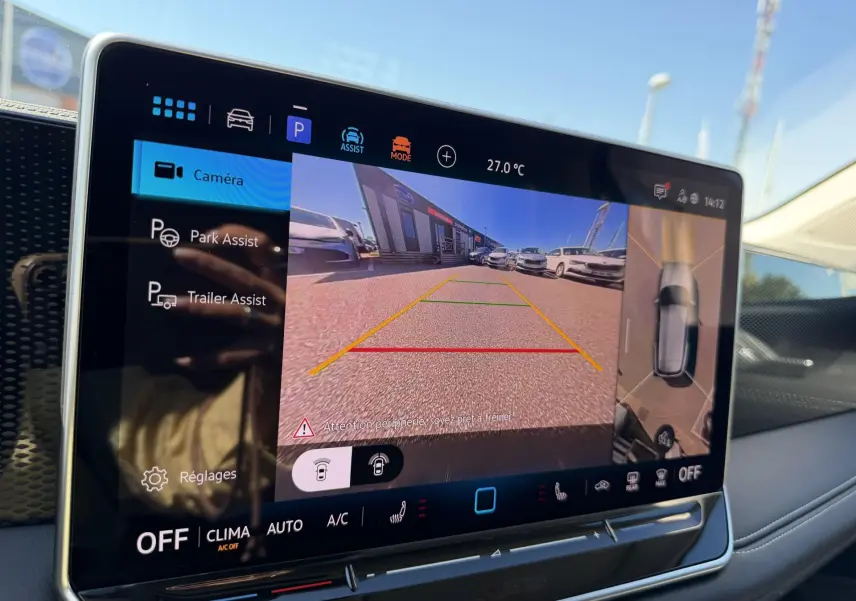 Écran tactile intérieur du Volkswagen Tiguan 2025 montrant l'assistance au stationnement avec vue caméra arrière.