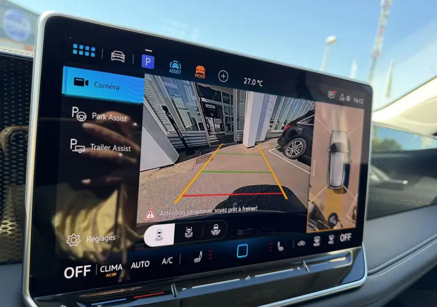 Écran tactile intérieur du Volkswagen Tiguan 2025 montrant l'assistant de stationnement avec vue caméra arrière et angles morts.