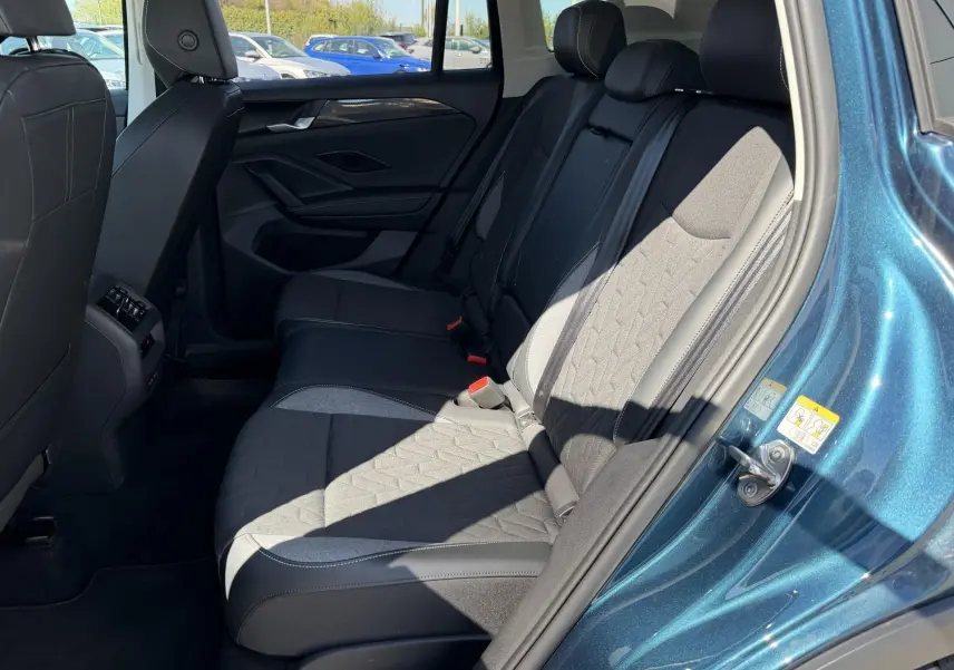 Vue côté droit des sièges arrière du Volkswagen Tiguan 2025 bleu, avec sellerie tissu et cuir noir contrasté.