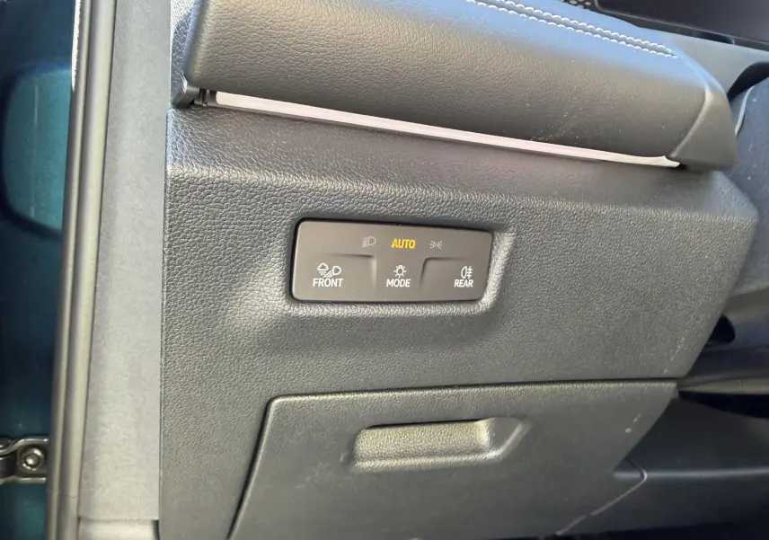 Détail du panneau de commande des feux avec mode automatique sur Volkswagen Tiguan 2.0 TDI bleu, côté gauche intérieur.