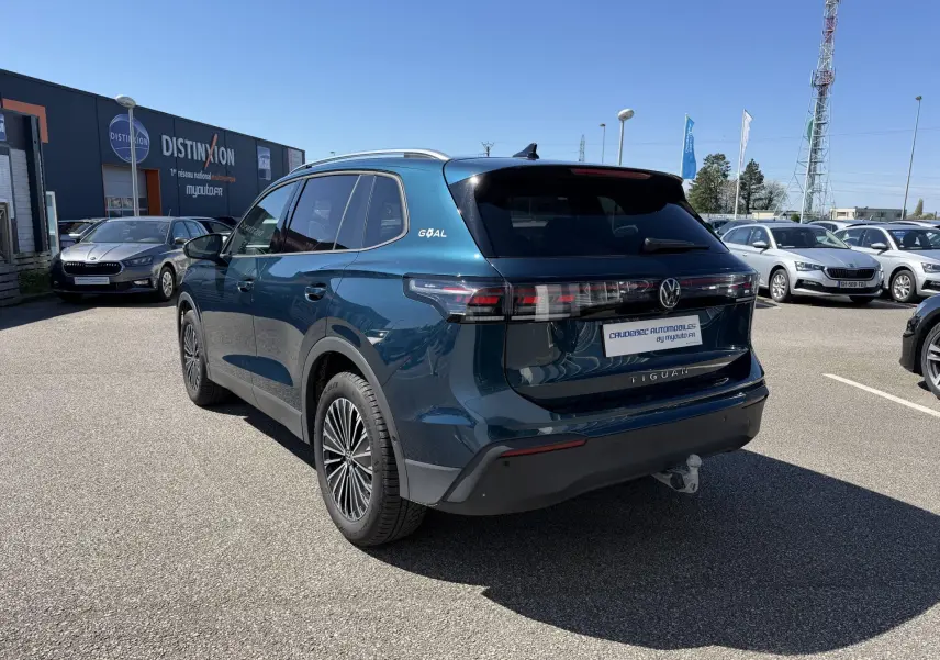 Volkswagen Tiguan bleu en 3/4 arrière droit avec crochet d'attelage escamotable et jantes alliage 18 pouces.