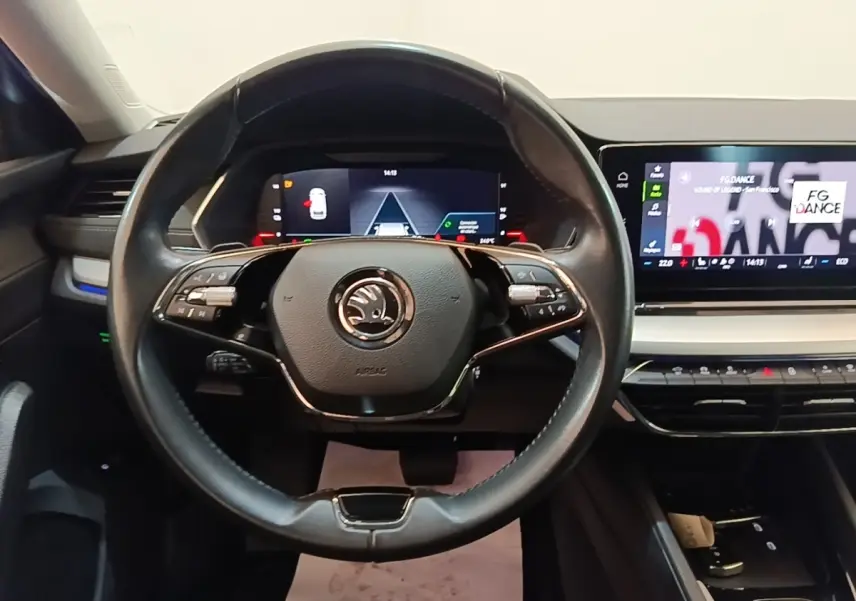 Vue intérieure centrée sur le volant cuir noir et les écrans digitaux du tableau de bord d'une Skoda Octavia 2022.