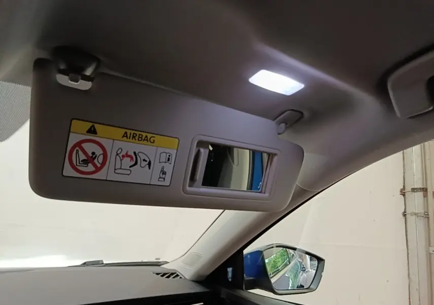 Détail intérieur du pare-soleil côté conducteur avec miroir et rétroviseur extérieur bleu visible sur Skoda Octavia 2022.