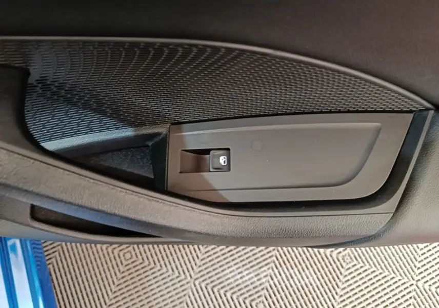 Détail de la commande de verrouillage sur la porte intérieure côté conducteur d’une Skoda Octavia bleue 2022.