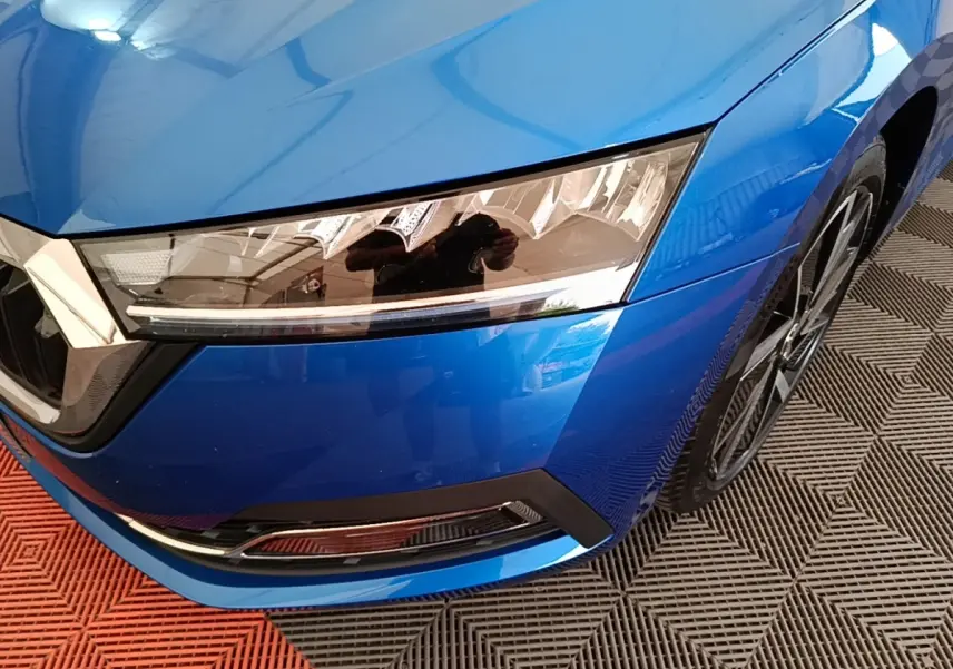 Gros plan sur l’avant droit bleu d’une Skoda Octavia 2022 avec phares LED et jante alliage visible.