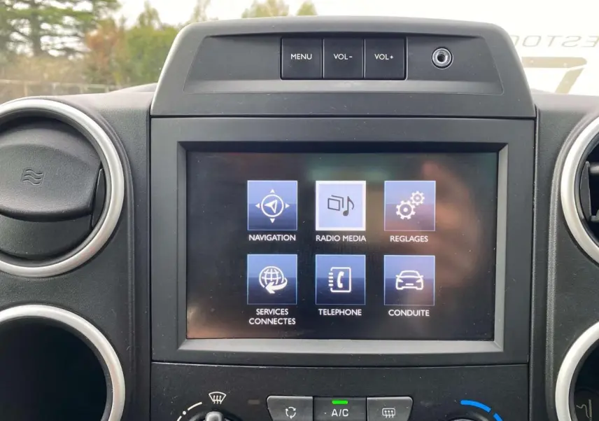 Écran tactile multifonctions du tableau de bord du Peugeot Partner TEPEE Active gris, avec commandes de navigation et média visibles.