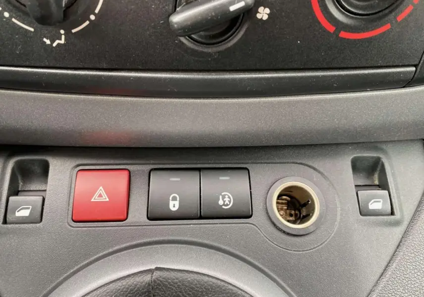 Gros plan sur la console centrale du Peugeot Partner 2017 avec boutons de verrouillage et allumage des feux de détresse.