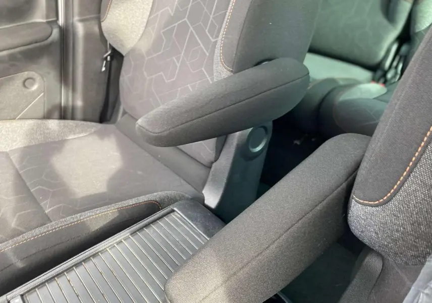 Gros plan sur les sièges avant gris foncé du Peugeot Partner 2017 avec accoudoirs et surpiqûres orange visibles.